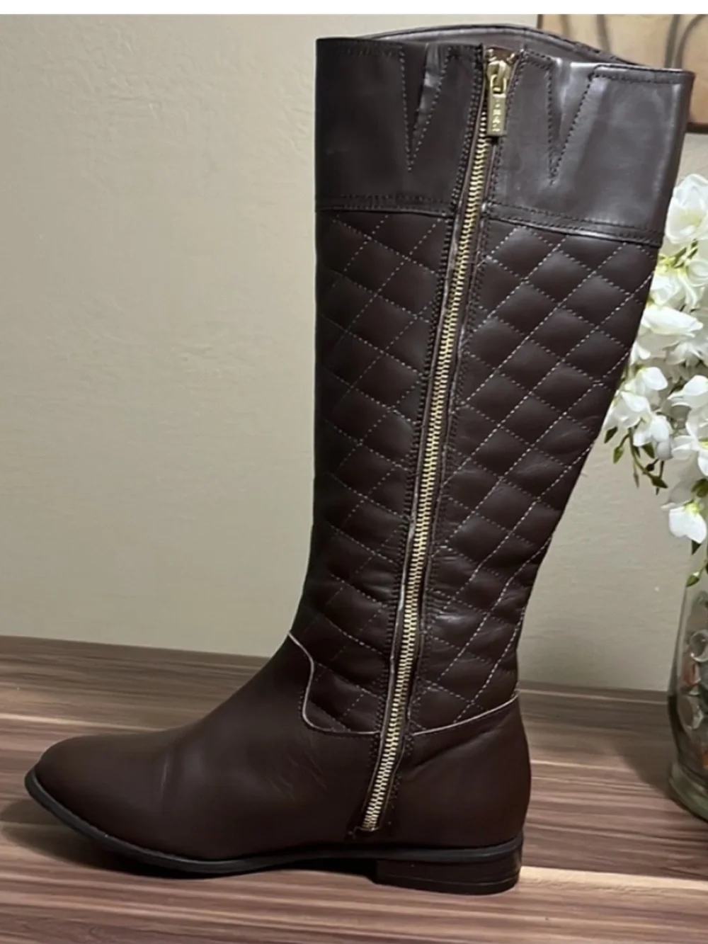 Iman Brown Quilted Knee-High Riding Boots with gold logo medallion